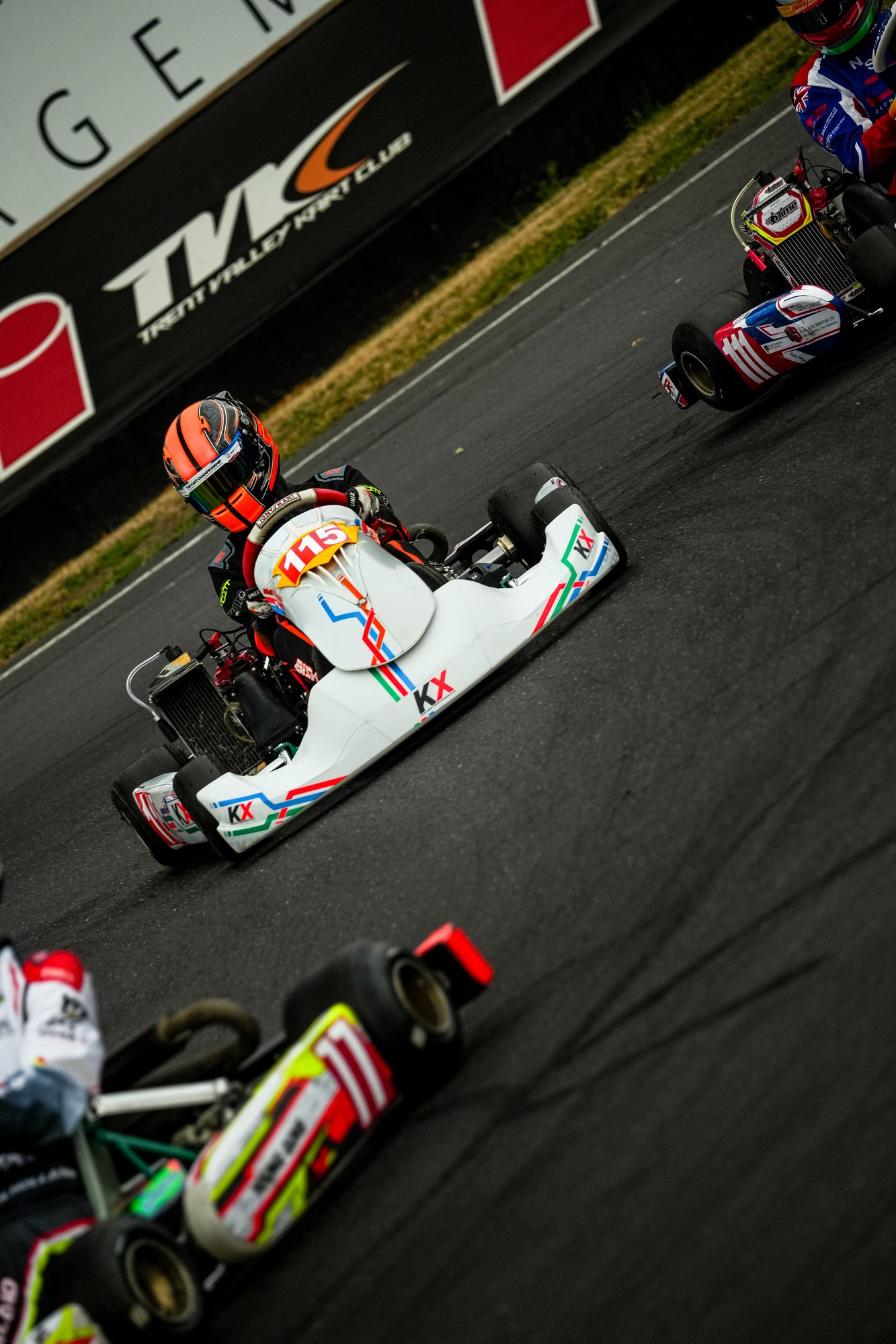 A kart on track with sponsor decals clearly visible on the nose and sidepod